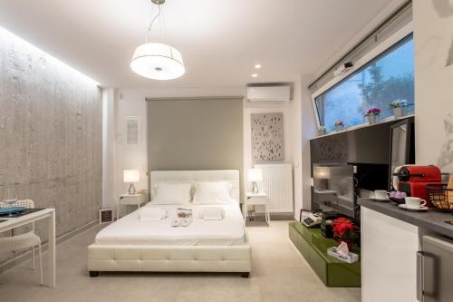 a bedroom with a white bed and a tv at Stadium HiEnd Studio Top Location in Athens