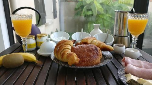 - une table recouverte d'une assiette de viennoiseries et de jus d'orange dans l'établissement La Touline, à La Jarne