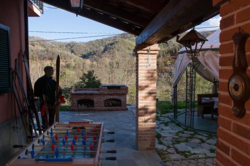 a man standing in front of a house with a brick fireplace at B&B Casa dell'Orso in Lurisia