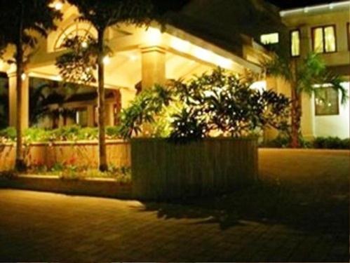 a house with trees and plants in front of it at Palm Meadows Resort in Bengaluru