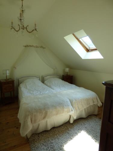 a bedroom with a white bed with a skylight at Le Clos des Camélias in Veulettes-sur-Mer