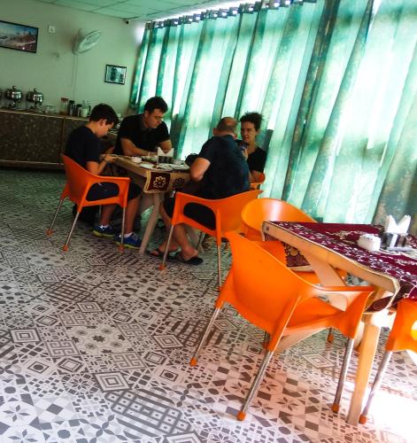 a group of men sitting at tables in a restaurant at Dwivedi Hotels Sri Omkar Palace in Varanasi