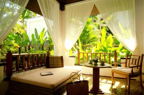 a room with a bed and a table on a balcony at Nakamanda Resort and Spa- SHA Plus in Klong Muang Beach