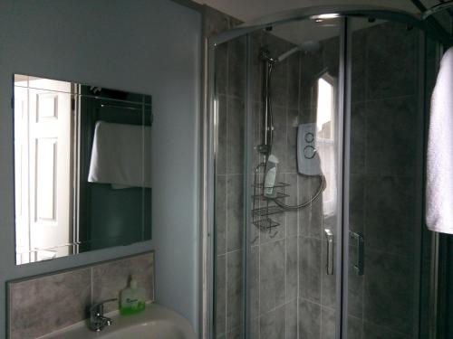 uma casa de banho com um chuveiro e um lavatório. em Rosslyn Court em Margate