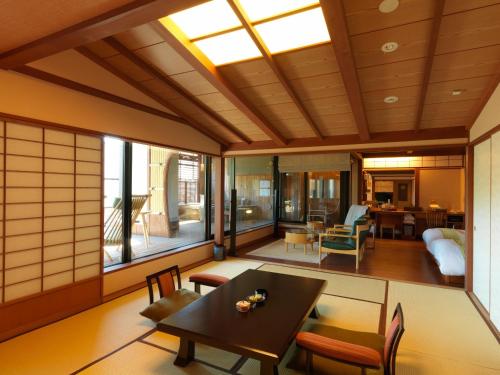 a japanese living room with a table and chairs at Akan Tsuruga Besso Hinanoza in Akankohan