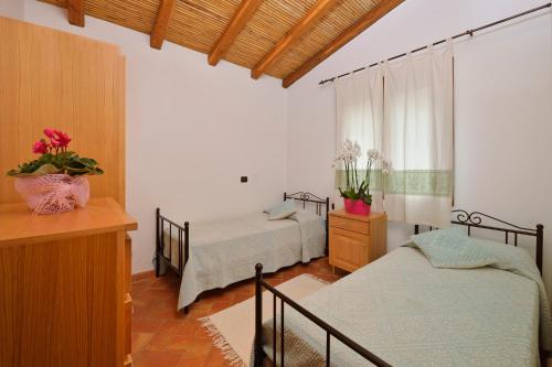 Villa Isuledda Beach tesisinde bir odada yatak veya yataklar