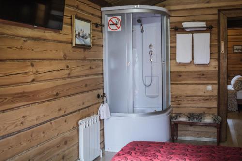 スーズダリにあるAlyonushkin Teremok Guest Houseの木製の壁のバスルーム(シャワー付)