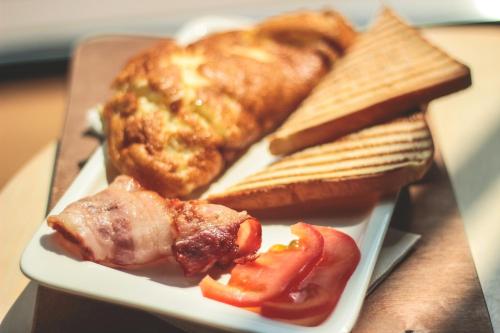 a plate of breakfast food with toast and a hot dog at La Rosa Hotel, Juffair in Manama