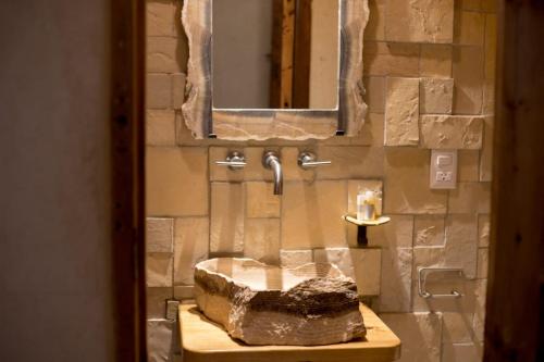 a bathroom with a stone sink and a mirror at Hotel Casa de Gandhi in San Cristóbal de Las Casas