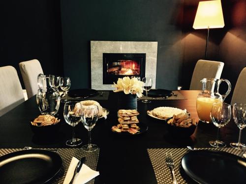 a black table with wine glasses and a fireplace at VILLA MARRONE - Relais - in Marsala