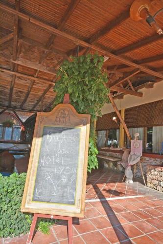 a chalkboard sign in front of a building at Lydia Hotel in Krinídhes
