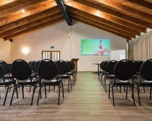 a room with rows of chairs in front of a screen at Taipa Beach Resort in Taipa