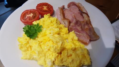 a plate of scrambled eggs and bacon and tomatoes at Ocean Heights B&B in Lissadell