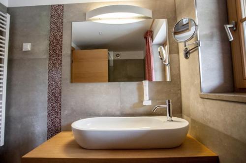 a bathroom with a white sink and a mirror at Penzion Repnik in Kamnik