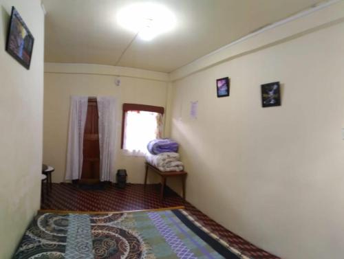 een kleine kamer met een bed en een raam bij Goshen homestay in Cherrapunji