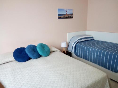 um quarto com 2 camas e almofadas azuis em B&B Fermo d'A Mare em Fermo