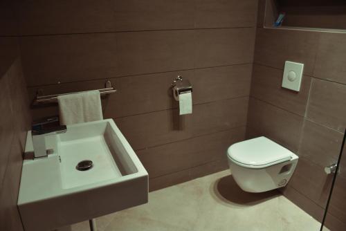 Łazienka z białą toaletą i umywalką w obiekcie Honor Appart Hotel w mieście Al-Funajdik