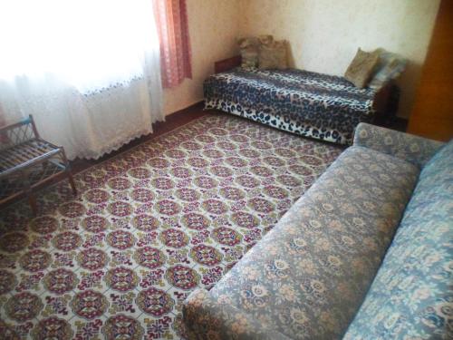 un soggiorno con divano e tavolo di Дача в Буймеровке a Buymerovka