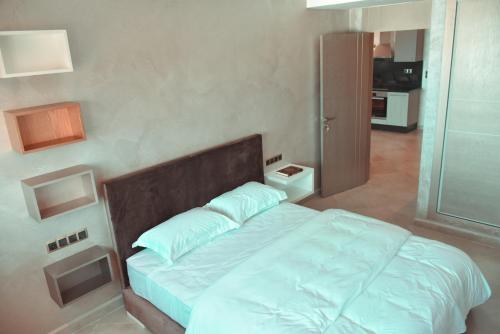 a bedroom with a large bed with white sheets at Honor Appart Hotel in Fnidek