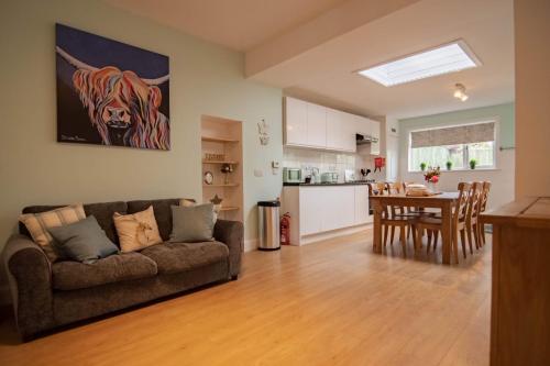 a living room and kitchen with a couch and a table at Wells Street Cottages No 26 By The River Ness in Inverness