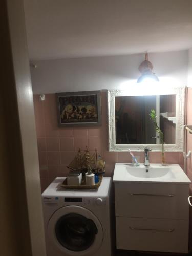 een badkamer met een wasmachine en een wastafel bij Art island house in Athene