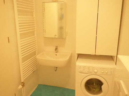 ein kleines Bad mit einer Waschmaschine und einem Waschbecken in der Unterkunft Your Place in Zagreb in Zagreb