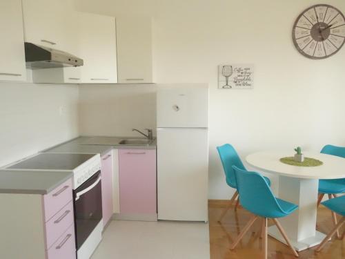 eine kleine Küche mit einem Tisch und blauen Stühlen in der Unterkunft Your Place in Zagreb in Zagreb
