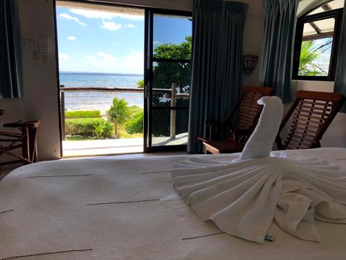 un vestido blanco en una cama con vistas al océano en Rancho Sakol en Puerto Morelos