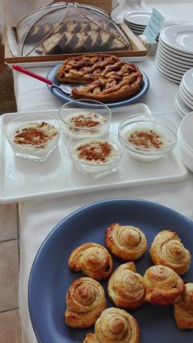 a table topped with plates of pastries and pies at Londos Hotel in Piso Livadi