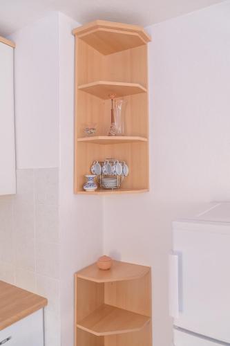 a kitchen with a wooden shelf with dishes on it at Fine Stay Apartments in Žirovnica