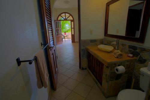 a bathroom with a sink and a toilet and a mirror at Las Turquezas in Puerto Escondido