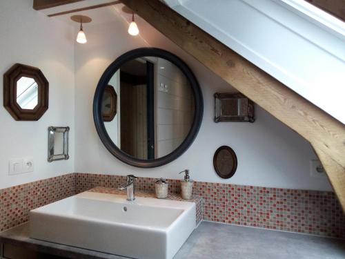 a bathroom with a sink and a mirror at L'écurie Kerdoel in Cléder