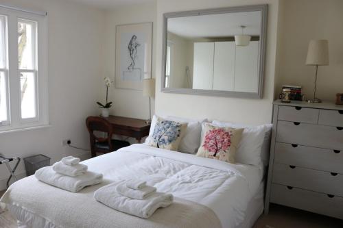 Un dormitorio con una cama blanca con toallas. en Tadmor Townhouse, en Londres
