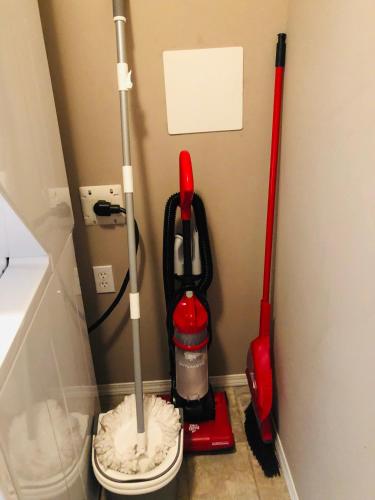 a room with two mop and a toilet in a corner at Quiet 2 Bed 2 Bath close to Westview Hospital in Stony Plain
