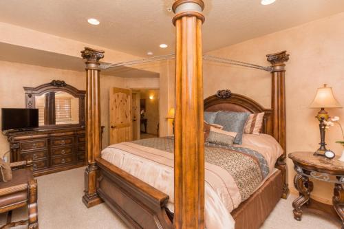 a bedroom with a four poster bed and a television at Luxury Townhouse in Wolf Creek in Eden