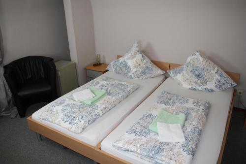 two beds in a room with blue and white pillows at Hotel Restaurant Balkan in Trier