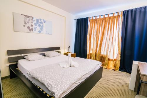een slaapkamer met een bed en een raam met blauwe gordijnen bij Imperial Suites in Boedapest