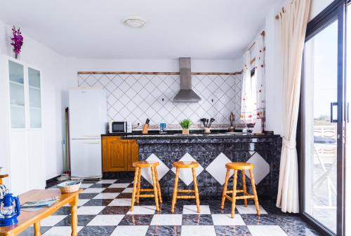 a kitchen with a black and white checkered floor at Vistamar La Caleta in La Caleta