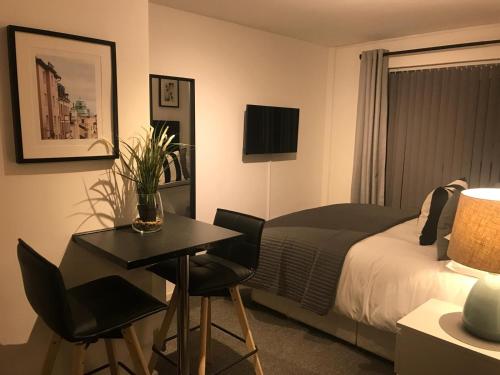 1 dormitorio con cama, mesa y escritorio en Glaisdale Studios en Wolverhampton