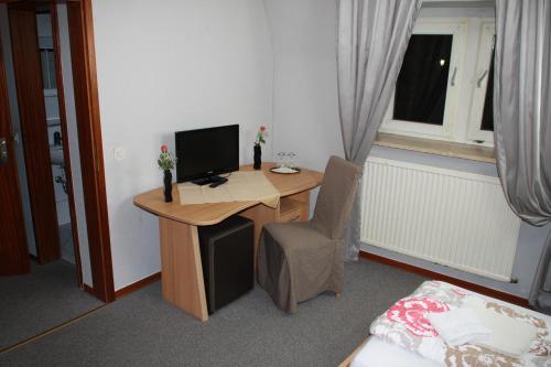 a desk with a computer and a chair in a room at Hotel Restaurant Balkan in Trier