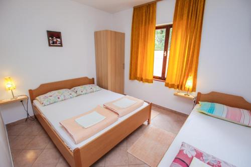 1 dormitorio con 2 camas y 2 ventanas en Apartments Ritoša, en Poreč