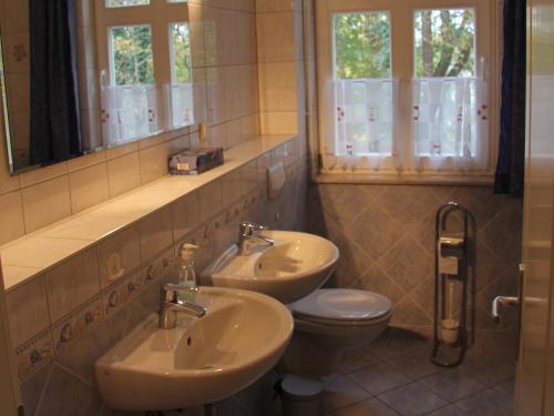 ツィノヴィッツにあるFerienwohnung Hofmannのバスルーム(洗面台2台、トイレ付)
