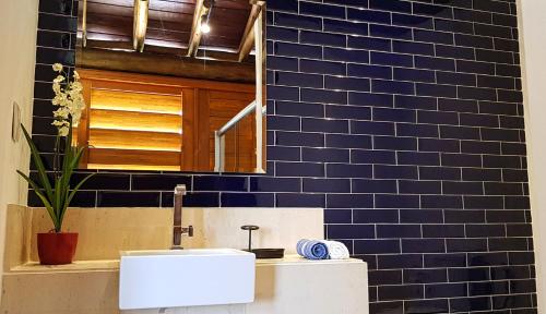 uma casa de banho com um lavatório e uma parede de azulejos azuis em Villa Bali, Praia do Forte em Praia do Forte