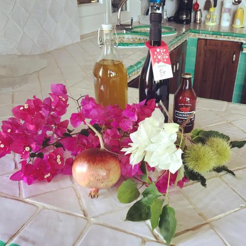 a bunch of flowers and bottles of wine on a counter at Residence Agape in Cefalù