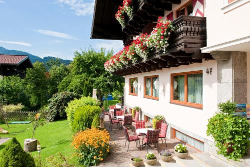 a patio with chairs and flowers on the side of a building at Landhaus Steiner in Altenmarkt im Pongau