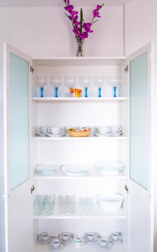 a white pantry with dishes and a vase at Vistamar La Caleta in La Caleta