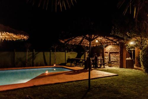 a swimming pool with an umbrella at night at Santa Teresita Boutique Hotel in San Fernando