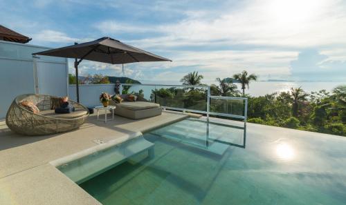 a house with a swimming pool and an umbrella at Sunset Paradise Villa in Haad Pleayleam