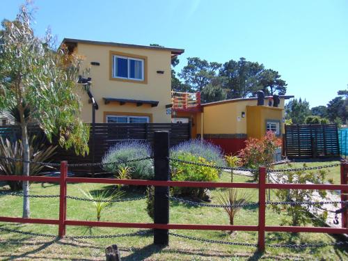 una casa con una valla delante de ella en Casa de Campo La Maribel en La Lucila del Mar