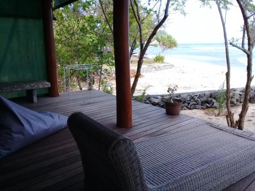 a wooden porch with a view of the beach at Castaway Surf Retreat in Sekongkang